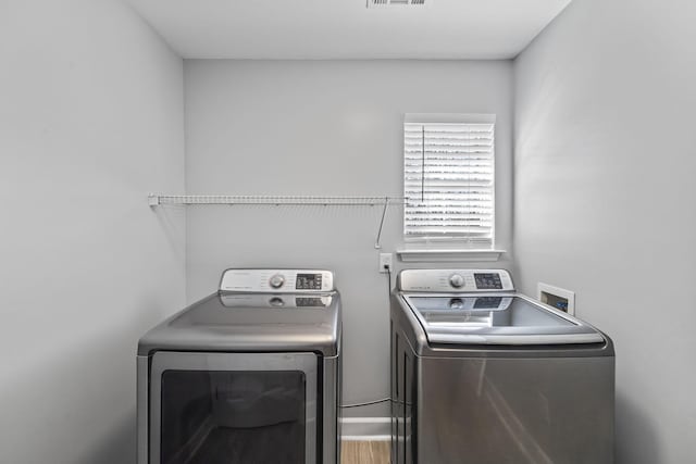 laundry room featuring laundry area, wood finished floors, visible vents, and independent washer and dryer