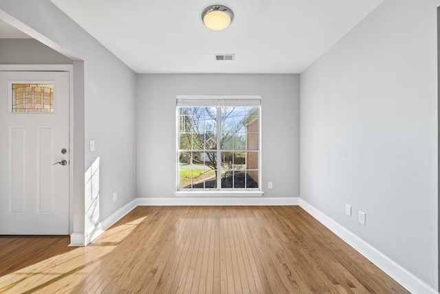 interior space featuring hardwood / wood-style flooring, baseboards, and visible vents