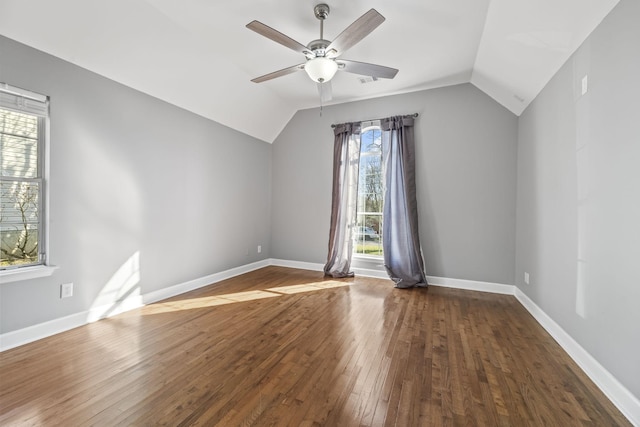 interior space with hardwood / wood-style floors, vaulted ceiling, a ceiling fan, and baseboards