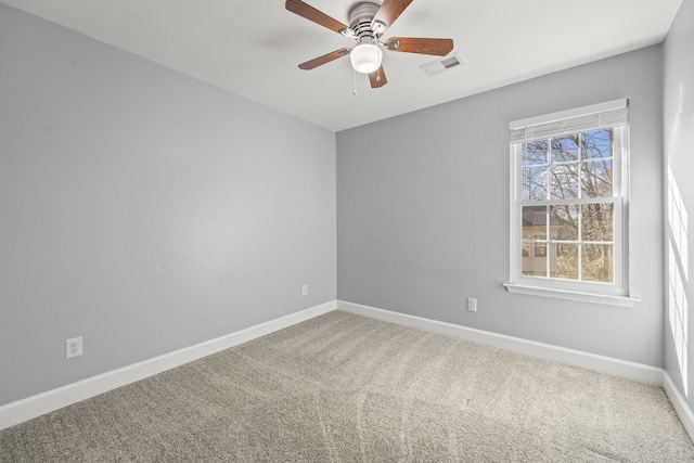 carpeted spare room with a ceiling fan, baseboards, and visible vents