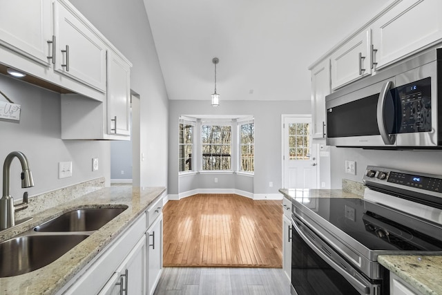 kitchen featuring white cabinets, light wood finished floors, appliances with stainless steel finishes, and a sink