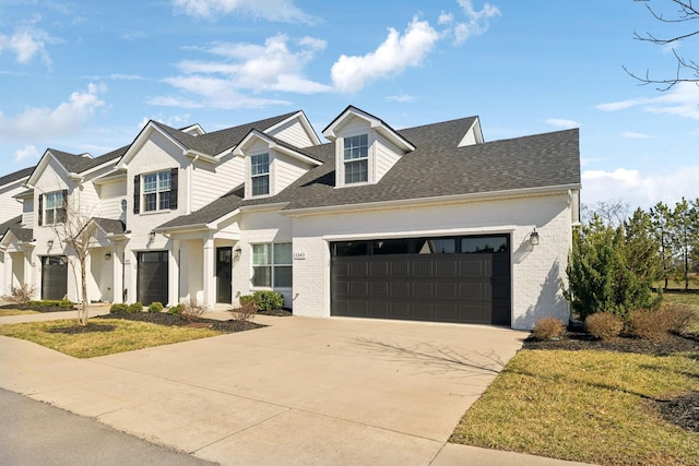 view of front of house featuring a garage, concrete driveway, and roof with shingles