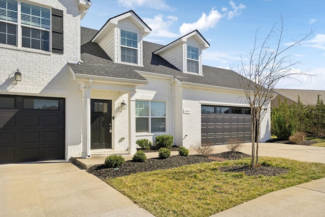 view of front of home with a garage, brick siding, concrete driveway, and roof with shingles