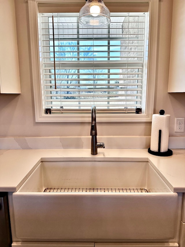 details featuring light countertops, a sink, and dishwashing machine