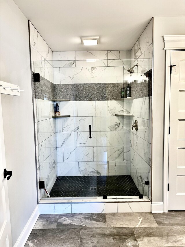 bathroom with a stall shower and baseboards