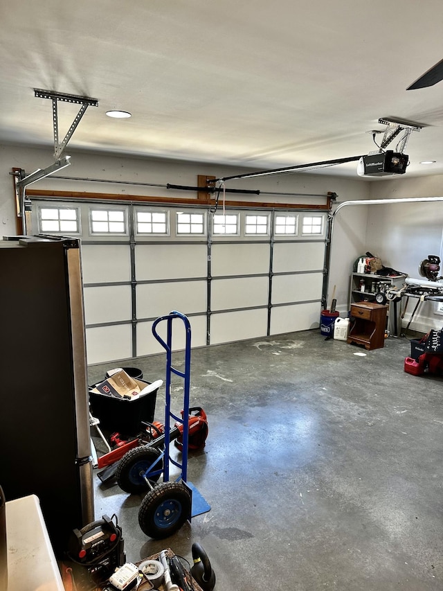 garage featuring a garage door opener and freestanding refrigerator