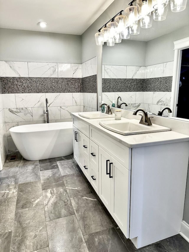 full bath featuring a freestanding bath, tile walls, and a sink