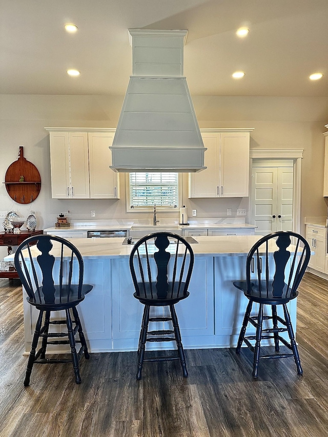 kitchen featuring white cabinets, light countertops, dark wood finished floors, and custom exhaust hood