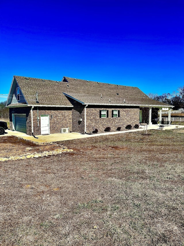 rear view of property with a garage and a patio