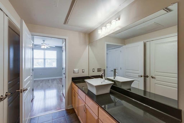 full bathroom with double vanity, tile patterned floors, a sink, and baseboards