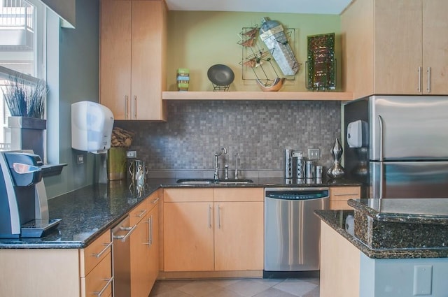 kitchen featuring dark stone countertops, a sink, stainless steel appliances, open shelves, and backsplash