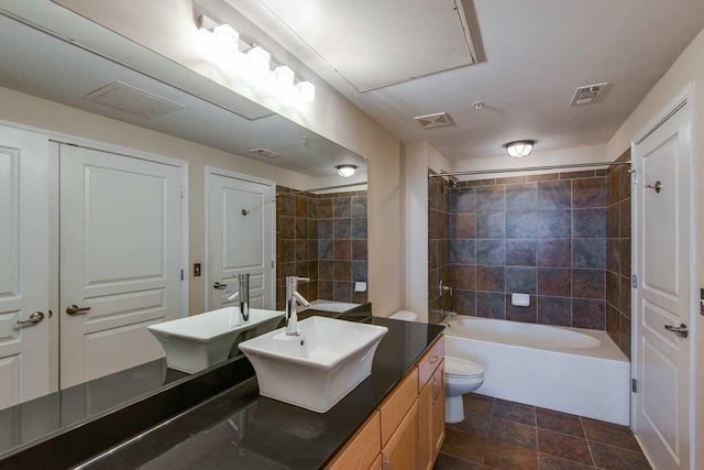 bathroom with toilet, visible vents,  shower combination, and vanity