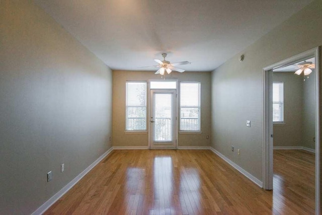 interior space with ceiling fan, light wood-style flooring, and baseboards