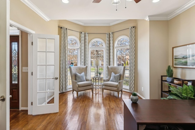 living area with ornamental molding and a healthy amount of sunlight