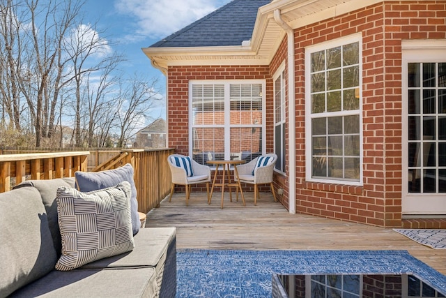 wooden terrace with an outdoor living space