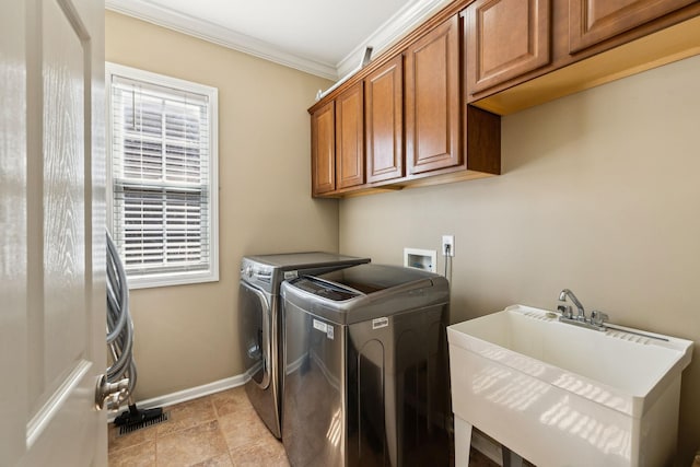 washroom with crown molding, washer and clothes dryer, cabinet space, a sink, and baseboards