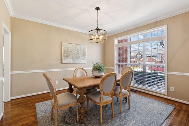 dining area with a chandelier, wood finished floors, and baseboards