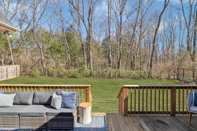 wooden terrace with fence, outdoor lounge area, a view of trees, and a yard