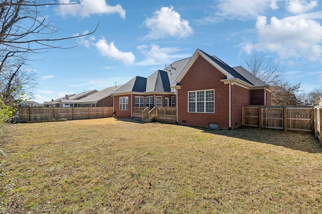 rear view of house with crawl space, a fenced backyard, a lawn, and brick siding