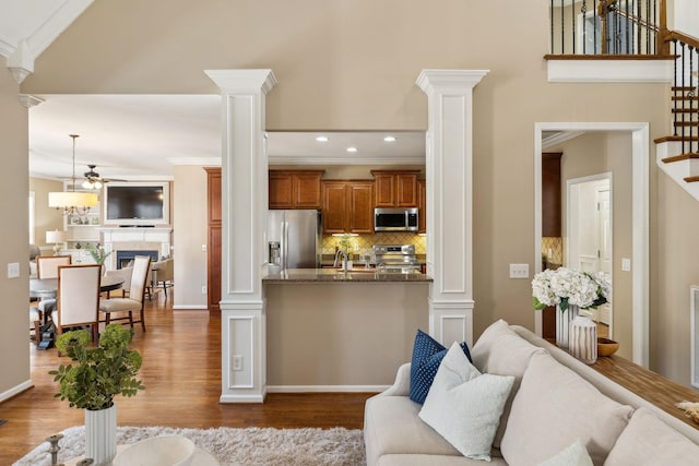 living room with ornate columns and dark wood-style flooring