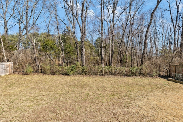 view of yard featuring fence and a view of trees