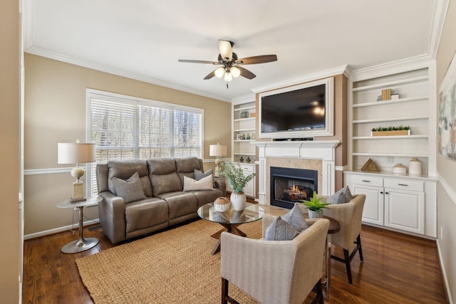 living room featuring dark wood-type flooring, a warm lit fireplace, crown molding, and ceiling fan