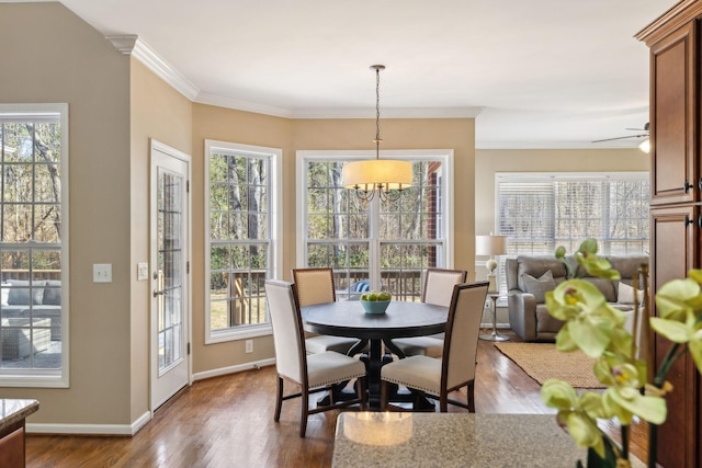 dining room featuring dark wood-style floors, ornamental molding, and baseboards