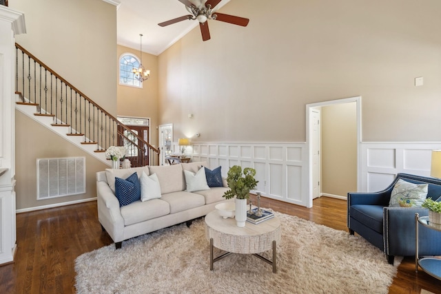 living room with high vaulted ceiling, visible vents, stairway, and wood finished floors