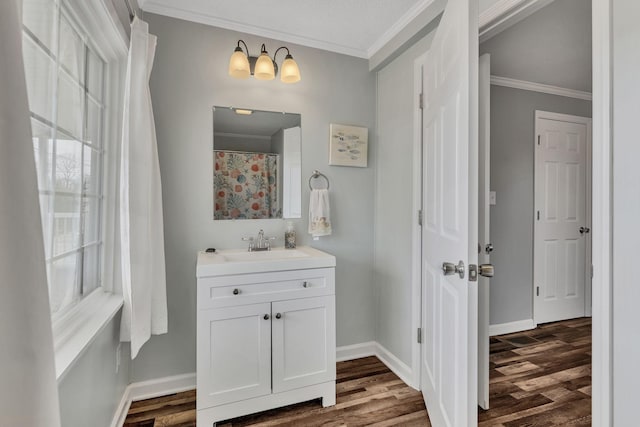 full bath with ornamental molding, wood finished floors, vanity, and baseboards