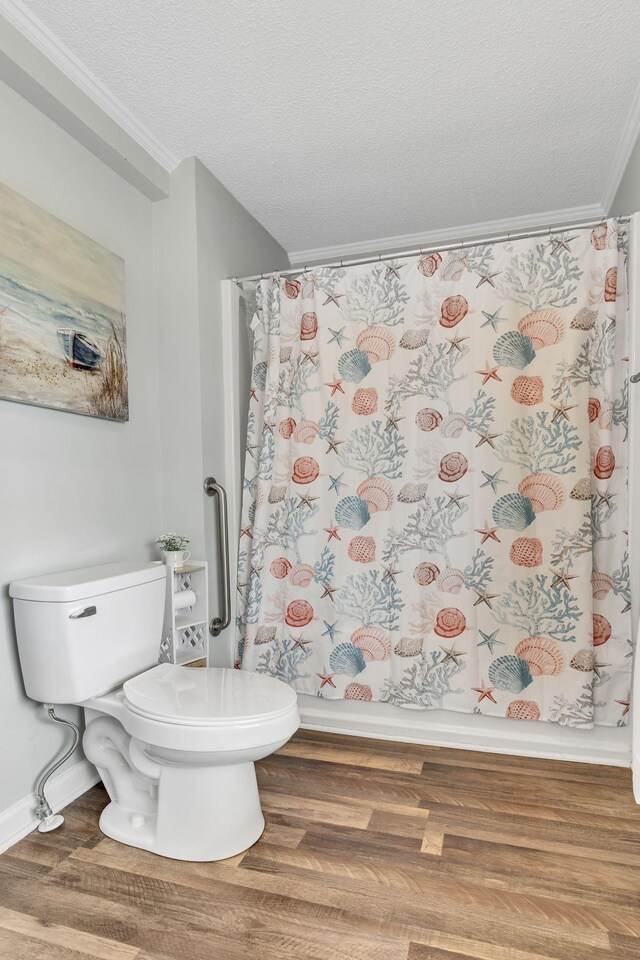 full bathroom featuring a textured ceiling, ornamental molding, wood finished floors, and toilet