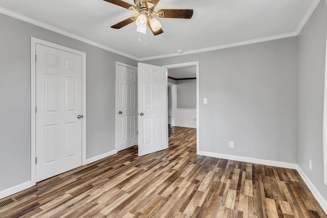 unfurnished bedroom with ornamental molding, wood finished floors, and baseboards