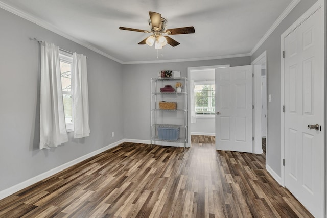 spare room with dark wood-style floors, crown molding, and baseboards