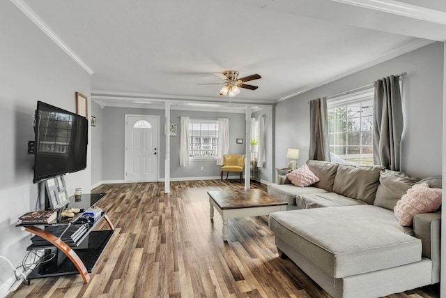 living room featuring a ceiling fan, baseboards, ornamental molding, and wood finished floors