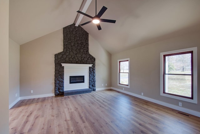 unfurnished living room featuring a large fireplace, baseboards, visible vents, beamed ceiling, and wood finished floors