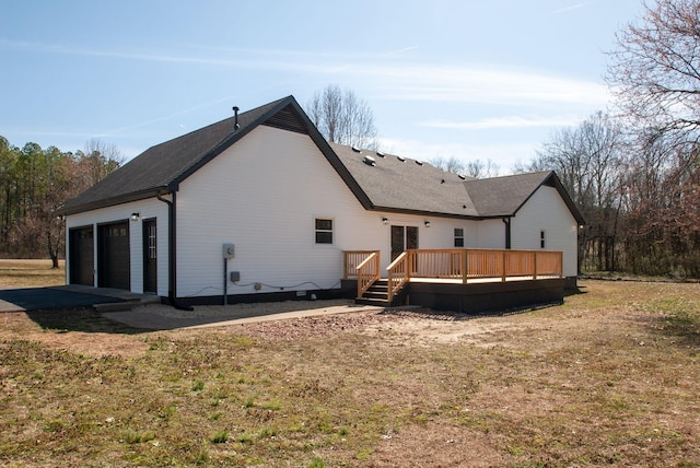 back of house featuring an attached garage and a deck