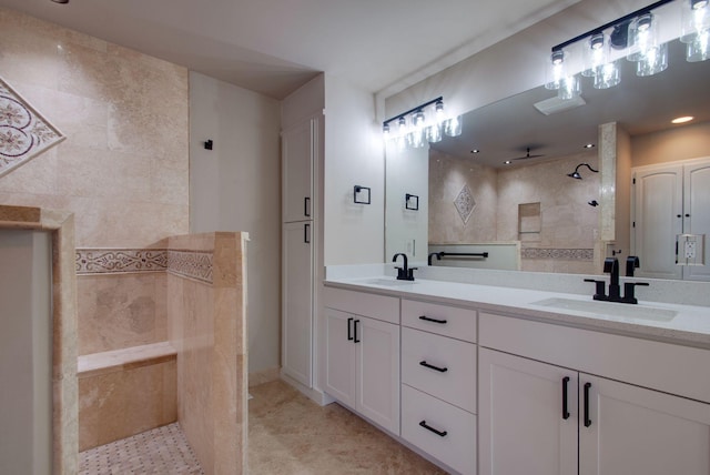 bathroom with a walk in shower, double vanity, and a sink