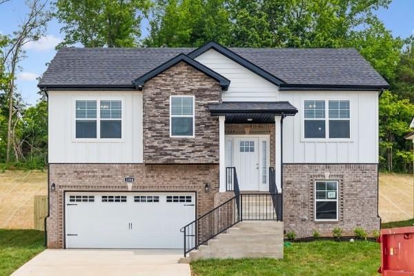 split foyer home with brick siding, board and batten siding, and driveway