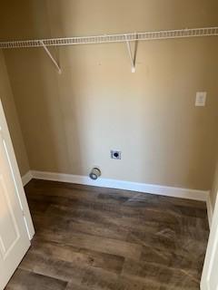 clothes washing area featuring baseboards, dark wood finished floors, and hookup for an electric dryer