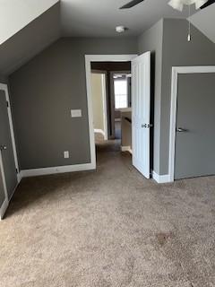 bonus room with vaulted ceiling, carpet flooring, a ceiling fan, and baseboards