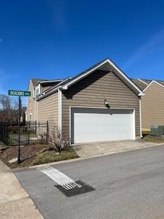 view of front facade with concrete driveway, fence, and an attached garage