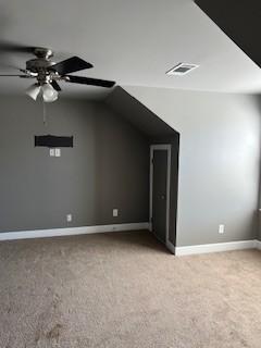 bonus room with lofted ceiling, visible vents, a ceiling fan, light carpet, and baseboards