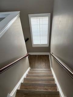 stairs with wood finished floors and baseboards