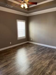 unfurnished room featuring dark wood finished floors, baseboards, visible vents, a raised ceiling, and crown molding