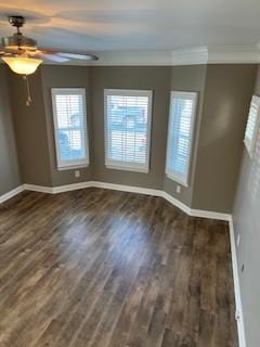 spare room with ornamental molding, dark wood-type flooring, and baseboards