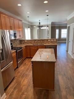 kitchen with ornamental molding, brown cabinets, a peninsula, stainless steel appliances, and a sink