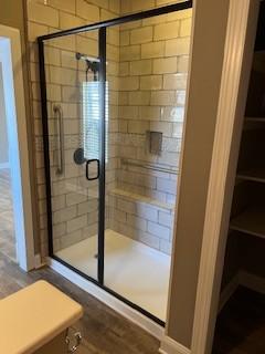 full bath with a shower stall and baseboards