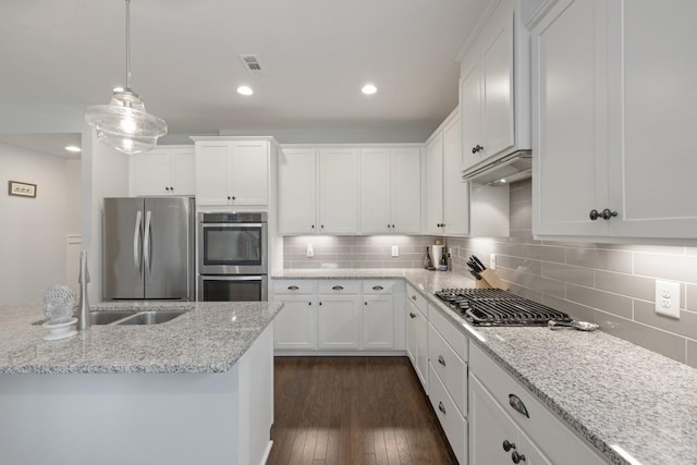 kitchen featuring appliances with stainless steel finishes, white cabinets, dark wood-type flooring, and visible vents