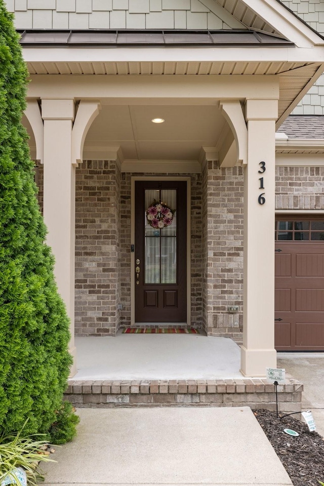 view of exterior entry with brick siding