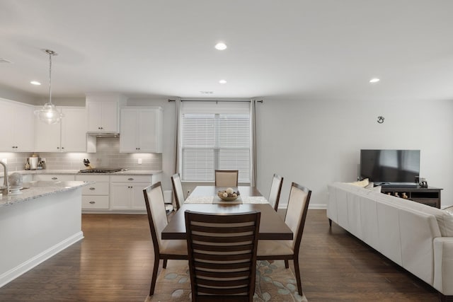 dining space with baseboards, dark wood finished floors, and recessed lighting