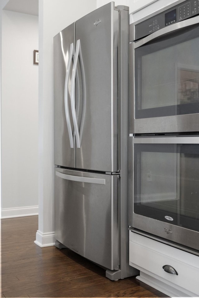 interior details with stainless steel appliances, baseboards, and dark wood-style floors